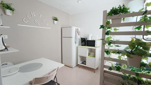 ein weißes Büro mit einem Schreibtisch und einem Kühlschrank in der Unterkunft CENTER Santa Cruz, Alojamiento céntrico con gran terraza, cocina , salón y baños, todo privado in Santa Cruz de Tenerife