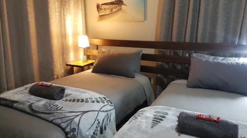 una habitación de hotel con 2 camas y una lámpara en President 21 en Bloemhof