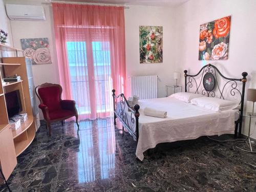 a bedroom with a bed and a red chair at Orchidea Mattinata parco del Gargano in Mattinata