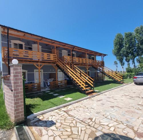 a house with wooden stairs on the side of it at Rental House Tale in Tale