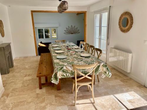 ein Esszimmer mit einem langen Tisch und Stühlen in der Unterkunft Maison en Normandie - 5 min plage Houlgate - Villers sur mer in Auberville