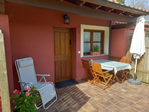 una casa con patio con mesa y sillas en Apartamentos Rurales Llagumelon, en Villahormes