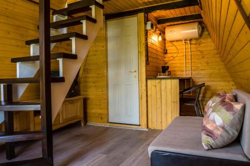 una sala de estar con una escalera en una cabaña de madera en Aquacool, en Crasna