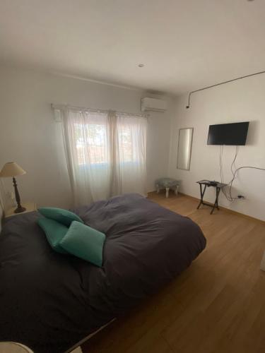 a bedroom with a large bed and a flat screen tv at Puerta 460 in Barraquero