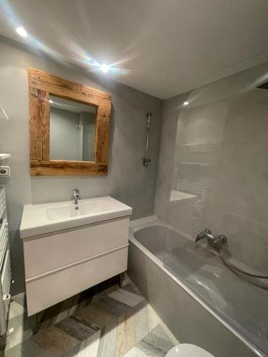 a bathroom with a sink and a tub and a mirror at Salamandra Panticosa in Panticosa