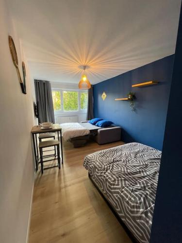 une chambre avec deux lits et une table et une fenêtre dans l'établissement L'Open d'Australie, à Chalon-sur-Saône