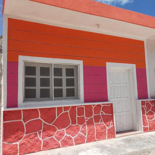 Casa colorida con ventana y pared en Departamento D'Marfil, en Yuluc