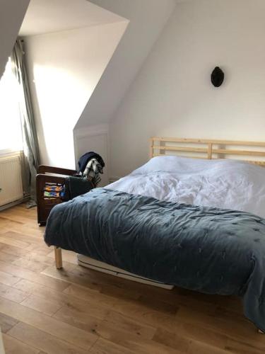 - une chambre avec un lit doté d'une couverture bleue dans l'établissement Appartement duplex refait à neuf calme et lumineux, à Paris