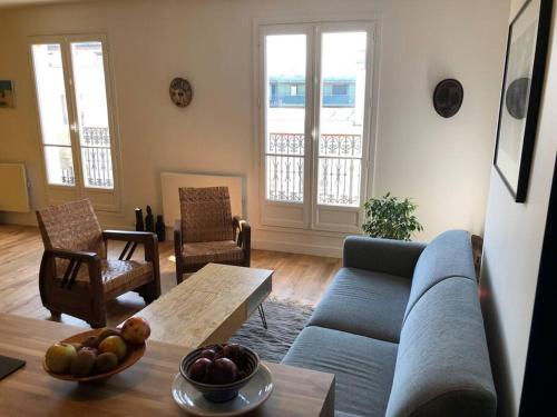 un salon avec un canapé bleu et une table dans l'établissement Appartement duplex refait à neuf calme et lumineux, à Paris