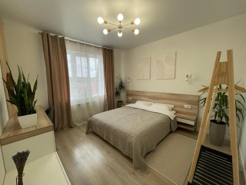 Schlafzimmer mit einem Bett und einem Fenster in der Unterkunft «ГОРИ́ЩЕ на площі Польський ринок» in Kamjanez-Podilskyj
