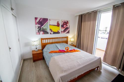 um quarto com uma cama com decorações laranja em Pandora apartment em Las Galletas