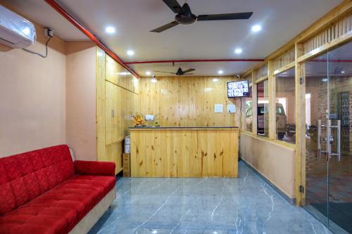 uma sala de estar com um sofá vermelho e uma televisão em Hotel Radha Krishna em Visakhapatnam