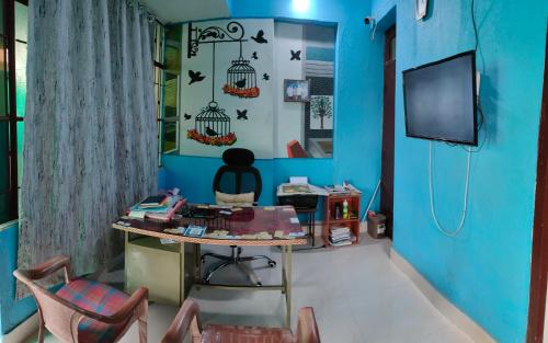 a room with a blue wall with a table and chairs at JoyNest Guest House in Patna
