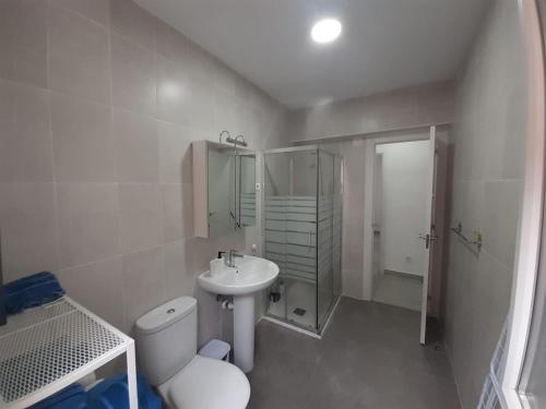 La salle de bains blanche est pourvue de toilettes et d'un lavabo. dans l'établissement CASA BARAKALDO, à Barakaldo