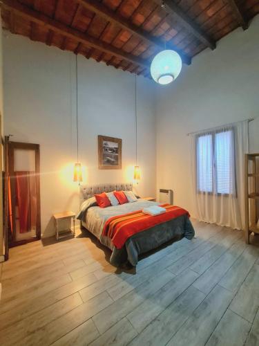a bedroom with a large bed with red pillows at Lechuza Alvear in San Antonio de Areco