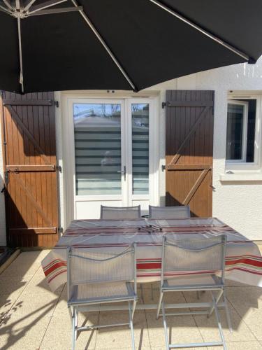 - une table de patio avec 2 chaises et un parasol dans l'établissement Villa patio Capbreton, à Capbreton