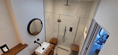 a bathroom with a shower with a sink and a mirror at Beachside luxury in Newquay