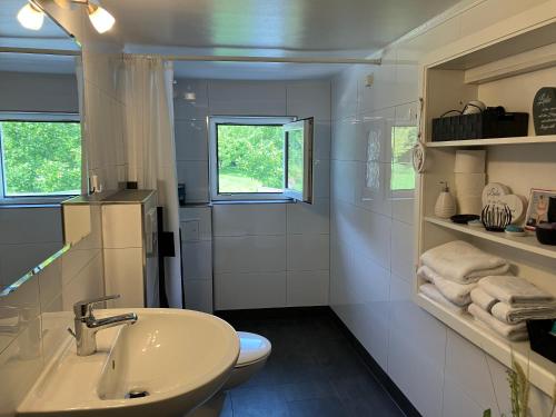 a white bathroom with a sink and a toilet at Ferienwohnung im Grünen mit Balkon in Herdecke