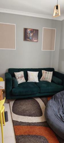 a living room with a green couch with pillows at Cutie homes_studio in Nairobi