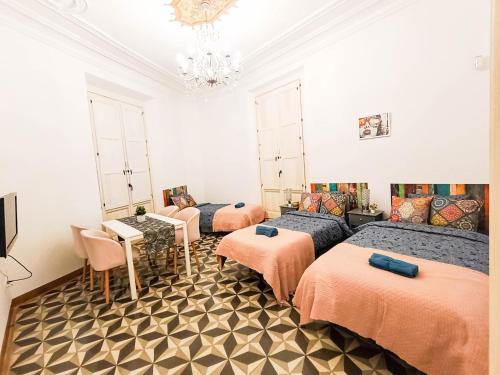 a room with four beds and a table and chairs at By Liceu Rooms in Barcelona