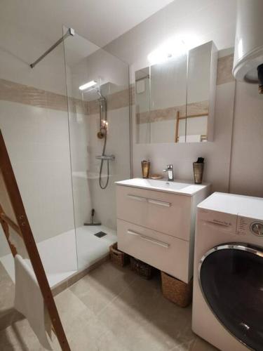 une salle de bain blanche avec une douche et un lavabo dans l'établissement Appartement avec terrasse en rez-de-jardin dans résidence avec piscine, tennis et aire de jeux, à Fréjus