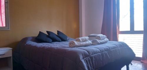 um quarto com uma cama com toalhas em Departamento Altos Mendoza Calle Chile Cochera Gratis! em Mendoza