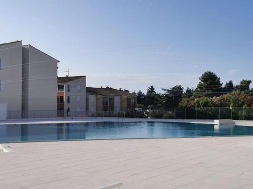une grande piscine devant une maison dans l'établissement Appartement avec terrasse en rez-de-jardin dans résidence avec piscine, tennis et aire de jeux, à Fréjus