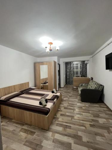 - une chambre avec un grand lit et un canapé dans l'établissement Apartament o camera Radoi, à Drobeta-Turnu Severin