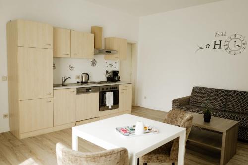 Porse Appartements في ماغدبورغ: غرفة معيشة مع طاولة بيضاء ومطبخ
