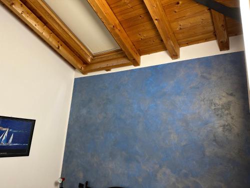 a room with a blue wall and wooden ceilings at Casa Rondinella in Negrar
