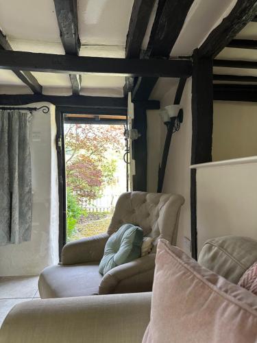 sala de estar con 2 sillas y ventana en Gorgeous Cottage in Skirmett with Parking en Henley on Thames
