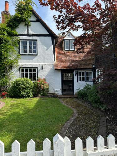 a white house with a white fence in front of it at Gorgeous Cottage in Skirmett with Parking in Henley on Thames