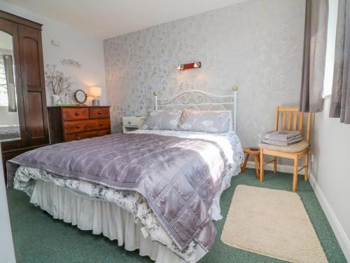 um quarto com uma cama, uma cómoda e uma cadeira em Stagsholt Lodge em Washfield