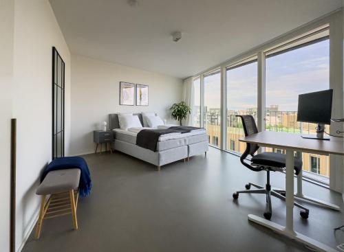 a bedroom with a bed and a desk with a computer at Exclusive Penthouse with Sunset Views in Copenhagen