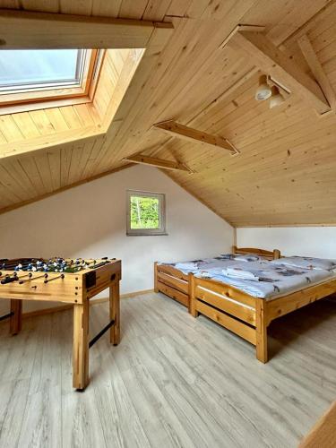 um quarto com duas camas e uma mesa num sótão em Magiczne Wzgórze em Ustroń