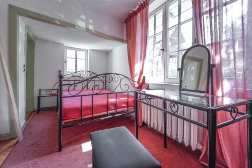 a bedroom with two beds and a mirror and a window at "Kleinstes Haus von Blankenburg" Urlaub in einem einzigartigen Baudenkmal in Blankenburg