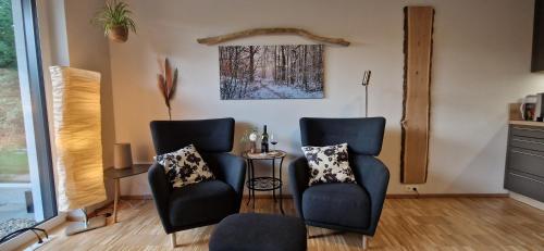 a living room with two chairs and a table at Place2be in Calden