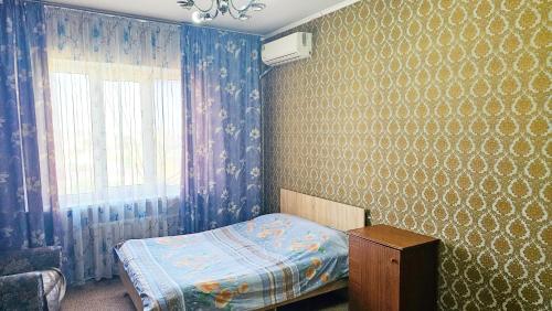 Schlafzimmer mit einem Bett und einem Fenster in der Unterkunft Apartment na VEFe in Bischkek