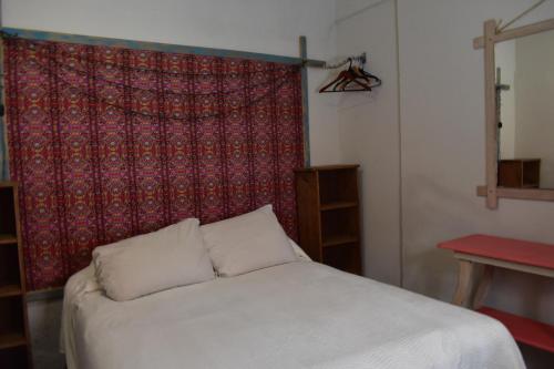 MONADita في سان كريستوبال دي لاس كازاس: سرير في غرفة ذات ستارة حمراء