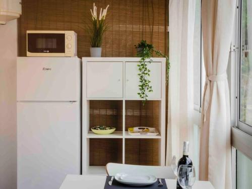 eine Küche mit einem weißen Kühlschrank und einem Tisch in der Unterkunft Apartamento en Puerto de la Cruz in Puerto de la Cruz