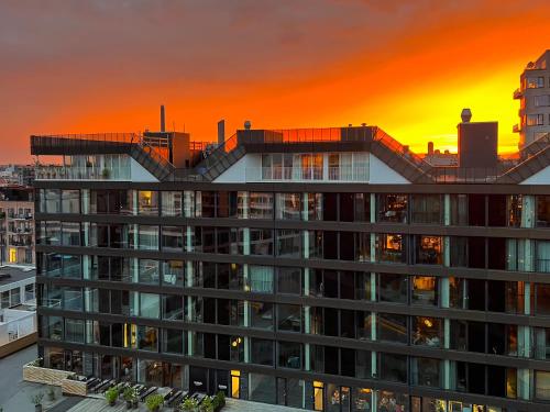 a building with a sunset in the background at Exclusive Penthouse with Sunset Views in Copenhagen