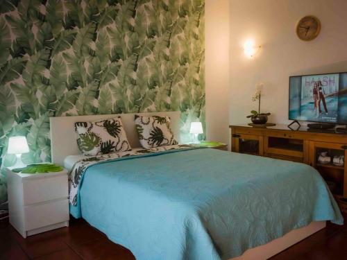 Schlafzimmer mit einem Bett mit blauer Tagesdecke in der Unterkunft Apartamento en Puerto de la Cruz in Puerto de la Cruz