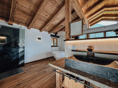 a large bathroom with a sink and a tub at Chalet Nordic mit privatem Whirlpool und Sauna in Bayrischzell