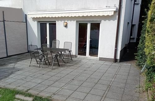 een patio met een tafel en stoelen naast een gebouw bij Julia's Monteur Oase - Premium Apartment exklusiv für Solo-Reisende in Ennepetal