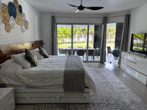 a bedroom with a bed and a television and a table at Mareazul Beachfront Resort - Casa Ancora in Playa del Carmen