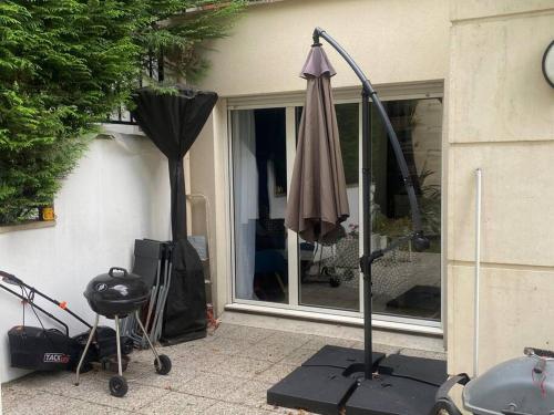 um guarda-chuva numa bancada ao lado de uma janela em Appartement proche de paris avec jardin em Meudon