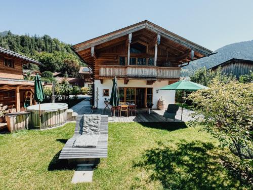 a log house with a deck and a patio at Chalet Nordic mit privatem Whirlpool und Sauna in Bayrischzell