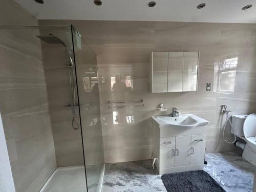 ein Bad mit einer Dusche und einem Waschbecken in der Unterkunft Exquisite Luxury Studio in Mitcham