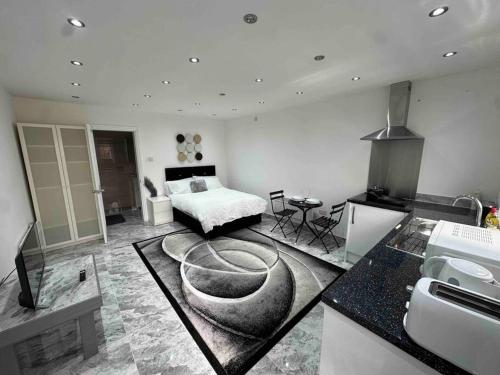 a living room with a bed and a kitchen at Exquisite Luxury Studio in Mitcham