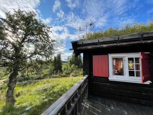 un edificio con una ventana en el lateral. en Elveseter - log cabin with an amazing view en Lunde